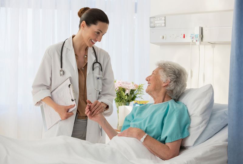 Doctor talking to patient in bed